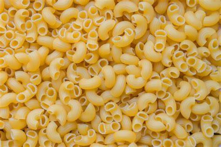 A close up of macaroni and cheese topped with sliced tomatoes.