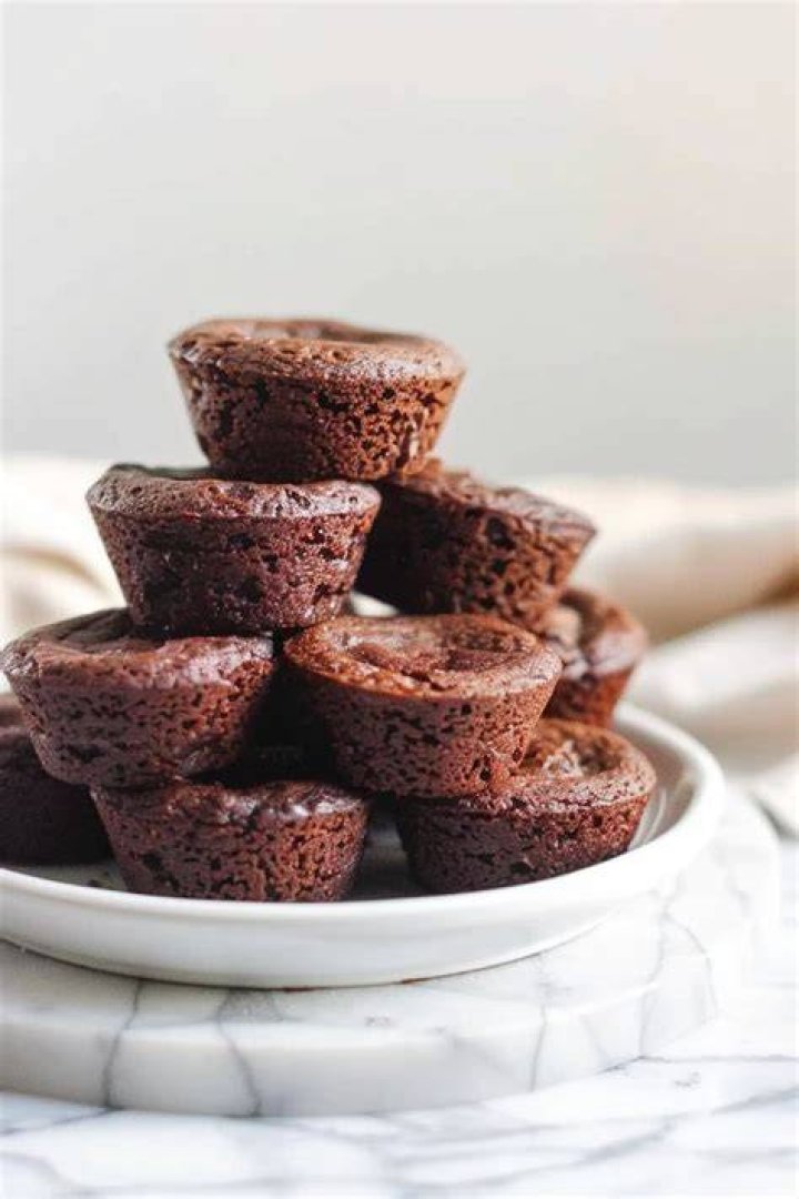 A stack of brownie bites on a white plate.