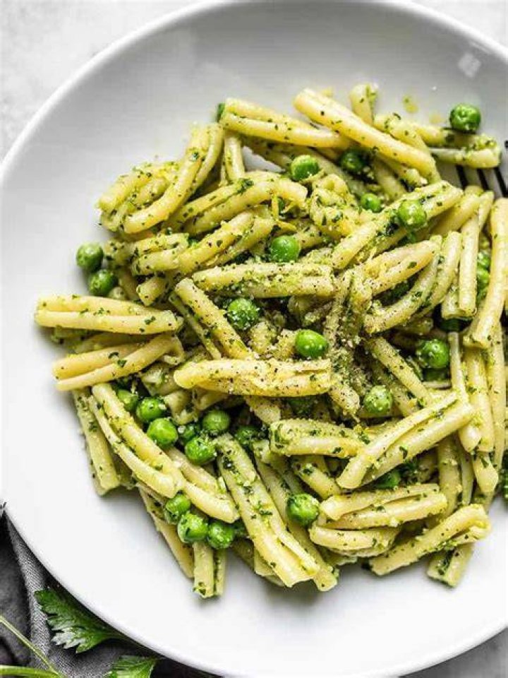 Pesto, pasta, and peas on a board.