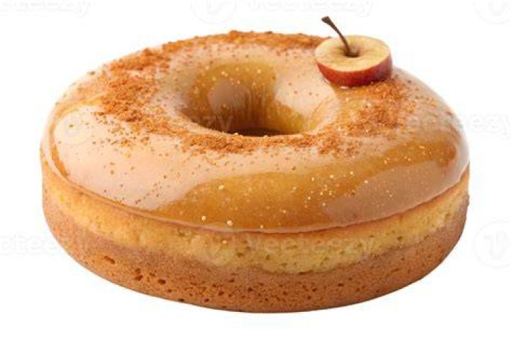 Slice of apple cider donut cake drizzled with caramel sauce and topped with whipped cream.